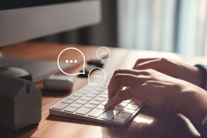 Woman hand typing on keyboard laptop with mobile smartphone, Live Chat Chatting on application Communication Digital Web and social network Concept