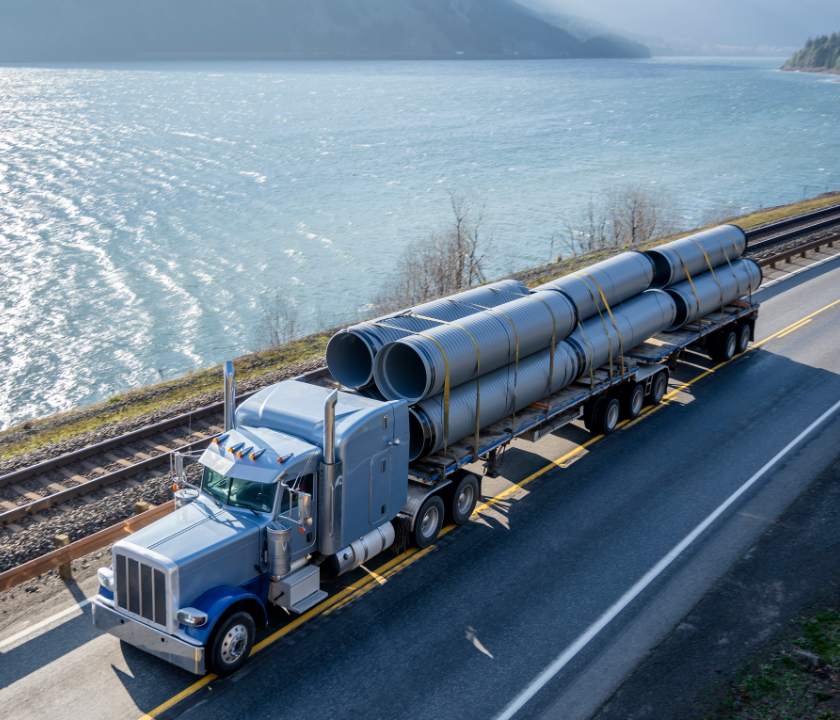 Truck hauling equipment on highway